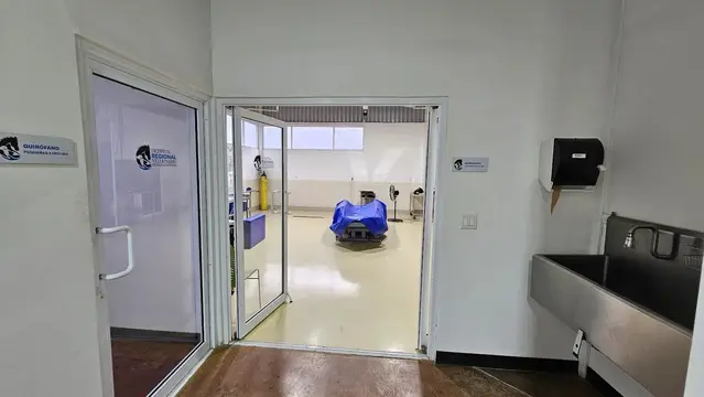 La entrada al quirófano de grandes especies, con la colchoneta azul al fondo y el lavabo quirúrgico de acero a un lado