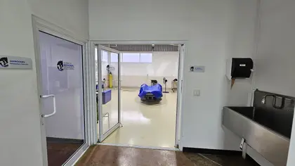 La entrada al quirófano de grandes especies, con la colchoneta azul al fondo y el lavabo quirúrgico de acero a un lado